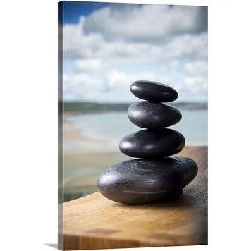 Premium Thick-Wrap Canvas entitled Pile of massage stones on wooden board in front of ocean